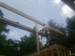 Carpenter setting a ridge beam over a new addition frame — Ice Dam Removal by Roofing Brothers in Sacred Heart