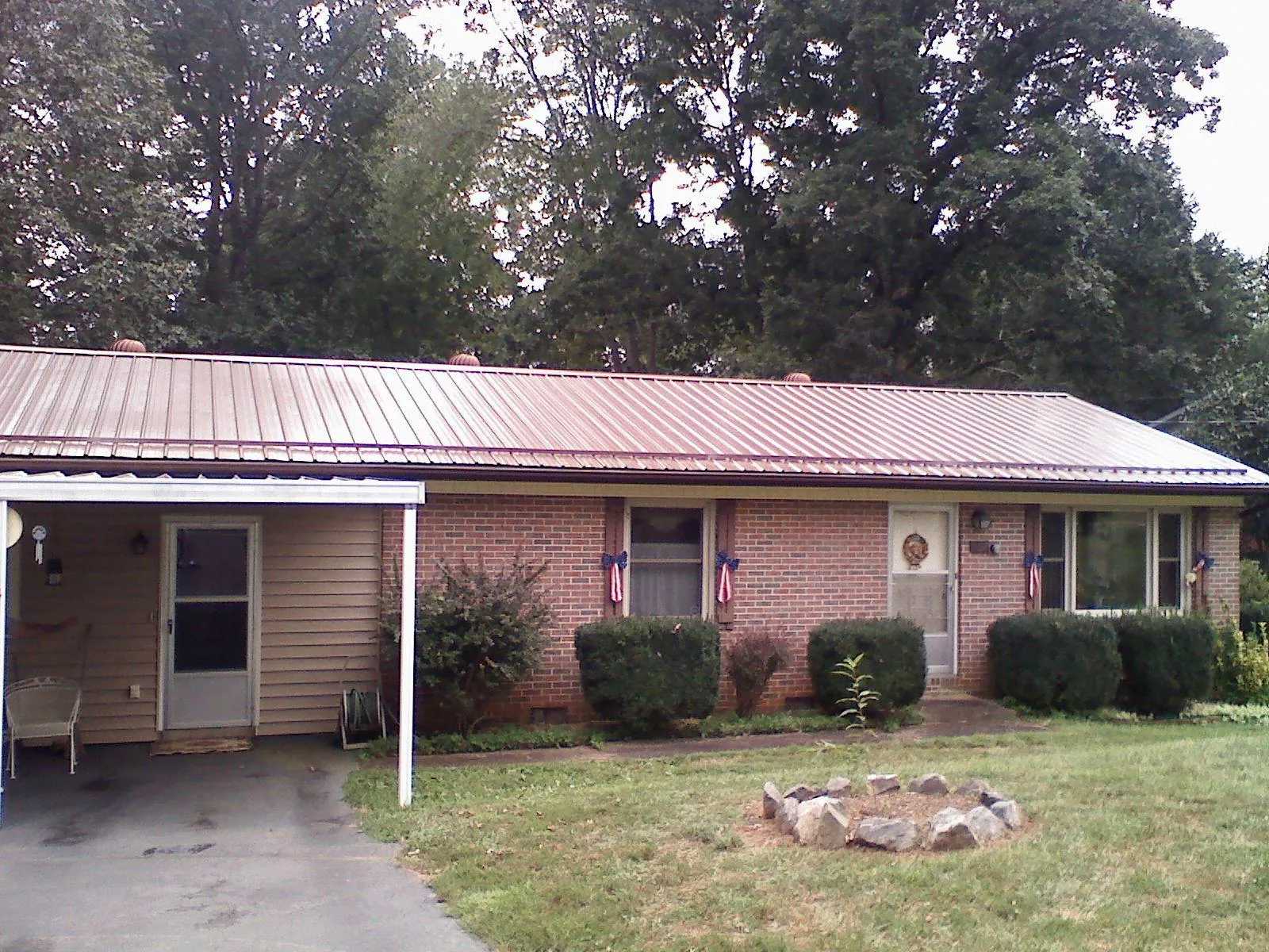 Bronze metal roof and carport on a brick ranch home — Roof Repair work by our crew in Sacred Heart