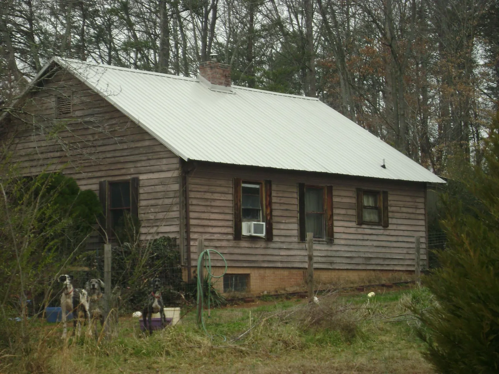 White metal roof on an old wood sided farmhouse, from a Metal Roof Installation job in Sacred Heart